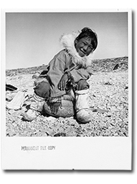 photo of smiling Ink child sitting on a rock