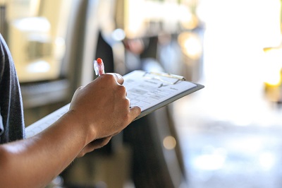 a person recording data by pen and paper