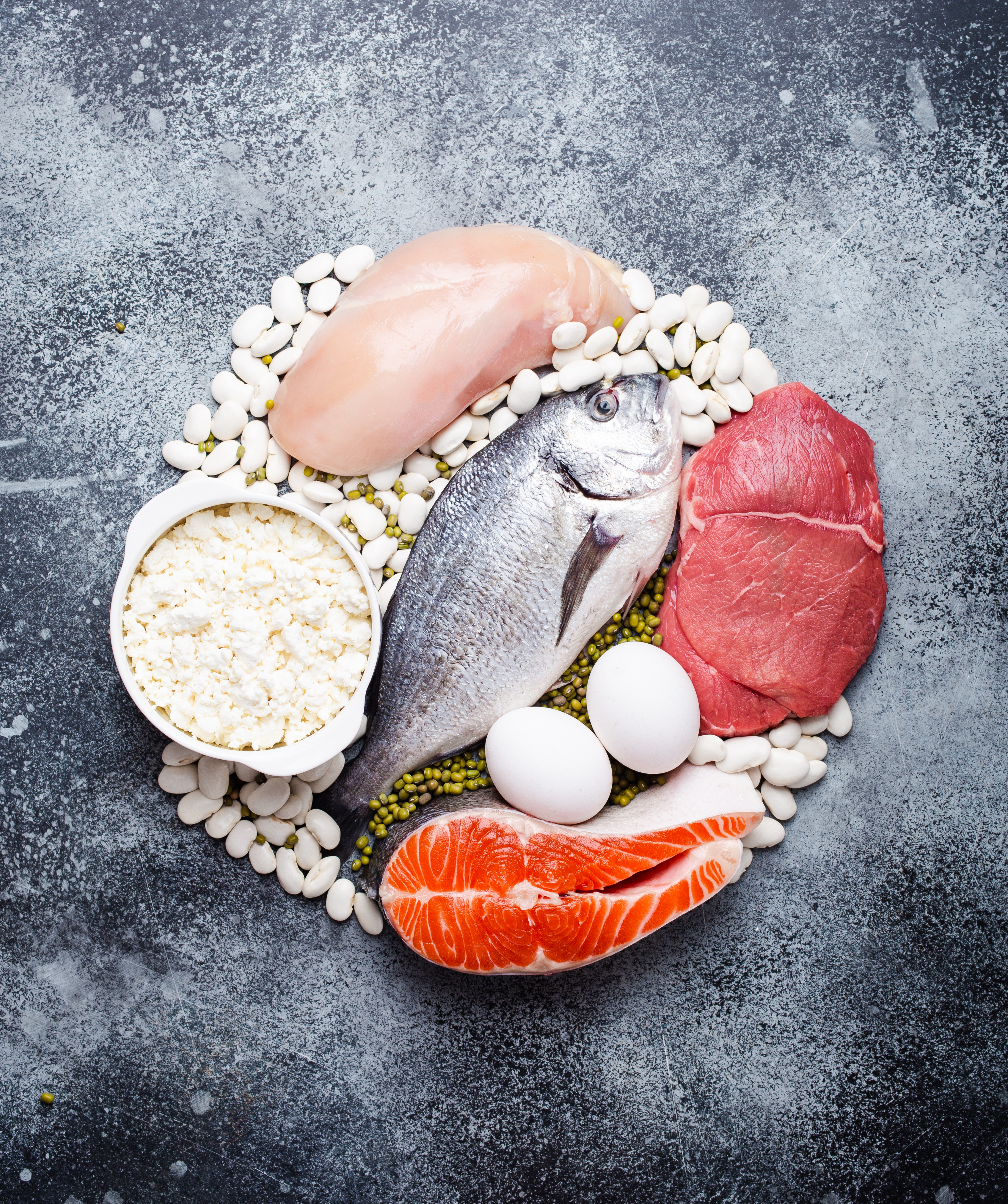 Photo of animal-based proteins such as beef, chicken, eggs, and fish are arranged on a counter