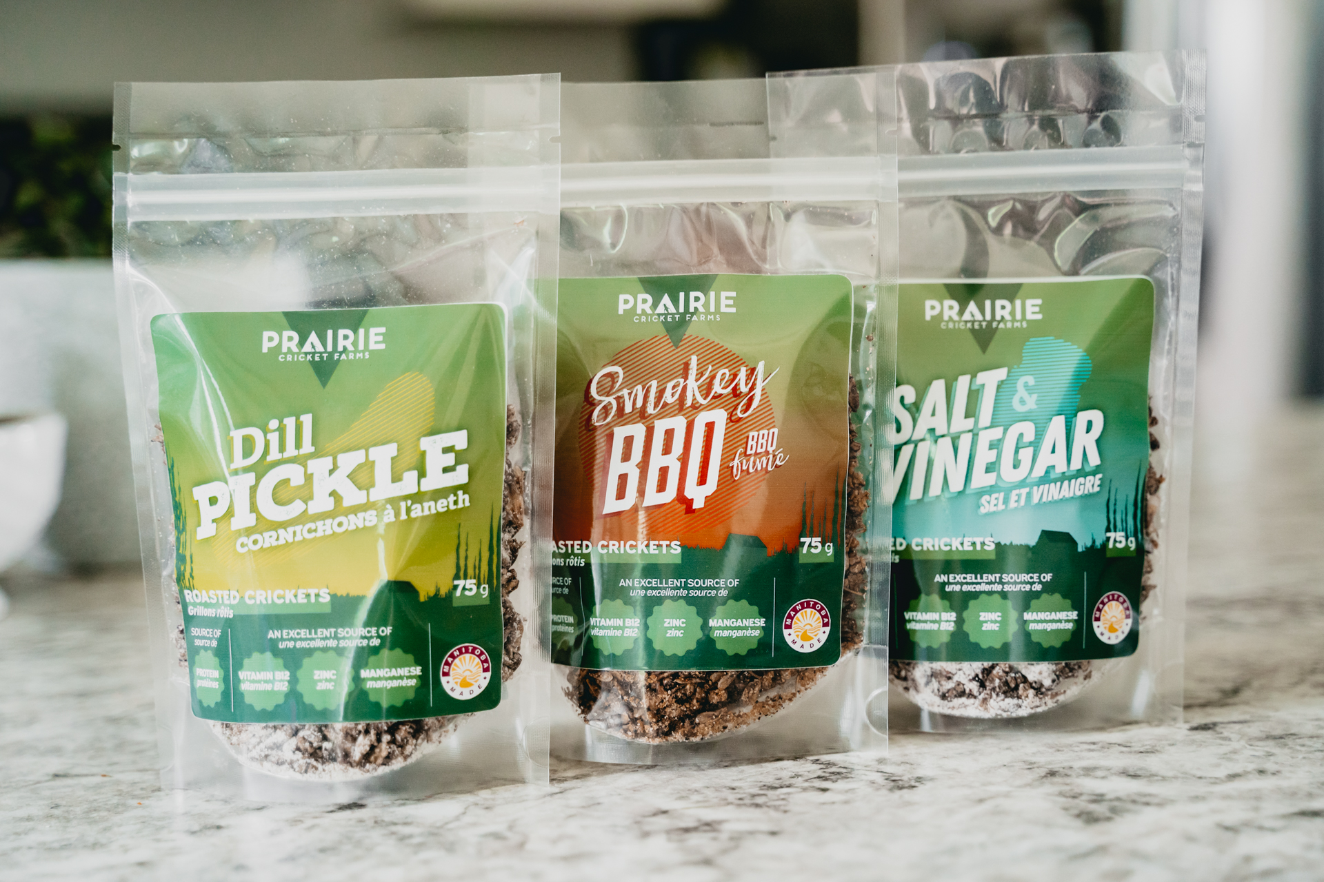 Photo of Prairie Cricket Farm's cricket snacks in three flavors on a counter