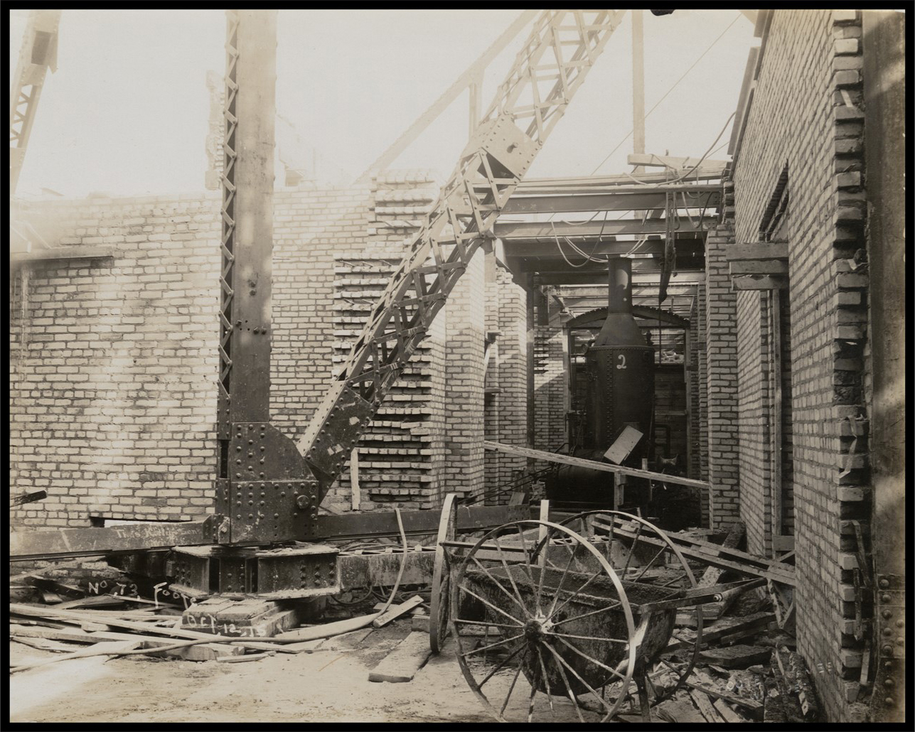 Interior portion of the building from the ground floor, with construction materials and mortar cluttering the area.