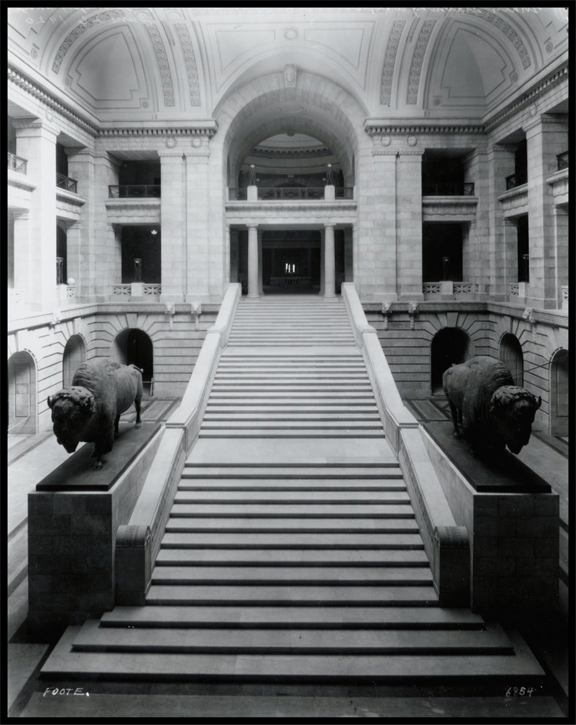 Photo of the completed Grand Staircase in the interior, with two large bison sculptures flanking the stairs. 