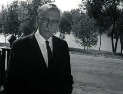 man in a suit in front of trees