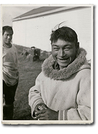 photo of smiling Inuk man with another Inuk man in background