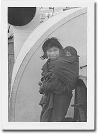 photo of young girl with a baby in a sling on her back