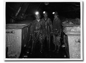 Photo of three men in a mine.