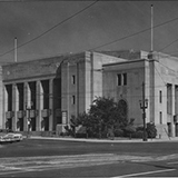 Wide shot of the Winnipeg Civic Auditorium in 1956 with cars parked on the street.
