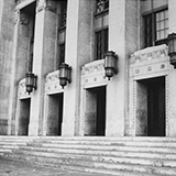 Photo of the front entrance of the Civic Auditorium building in 1939. The building has detailed moulding, large columns, multiple doorways, and lights attached to the building.