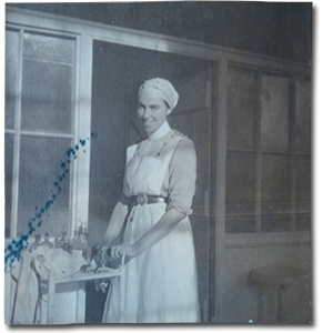 photo of Mina Mowat in a nurse uniform pushing a cart, captioned “Operating room at Moore Barracks, ‘Mowie’ in charge 1915”