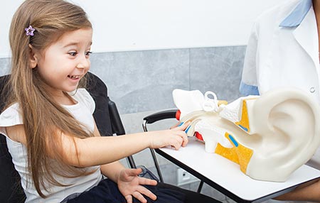 Child pointing at mode of an ear