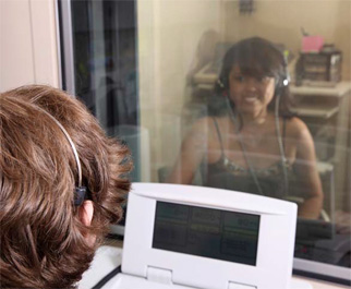 a person is looking through a window at a person wearing headphones