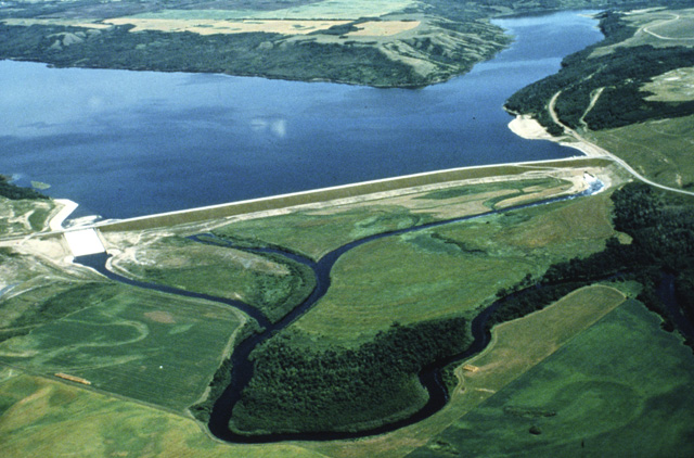An aerial view of Shellmouth Dam and Reservoir (Lake of the  Prairies) looking upstream. Upper right is the Shell River. The outlet is on  the right hand side of the photo and the spillway is on the left hand side of  the photo.