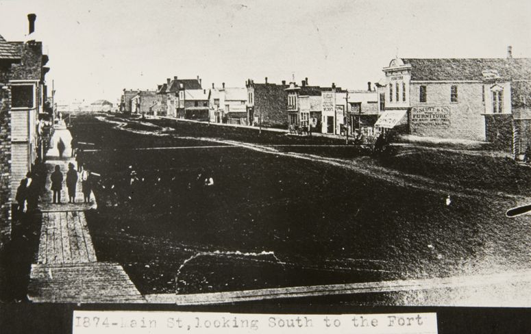 Main Street looking south from Graham Avenue showing the wide mud road and boardwalks.